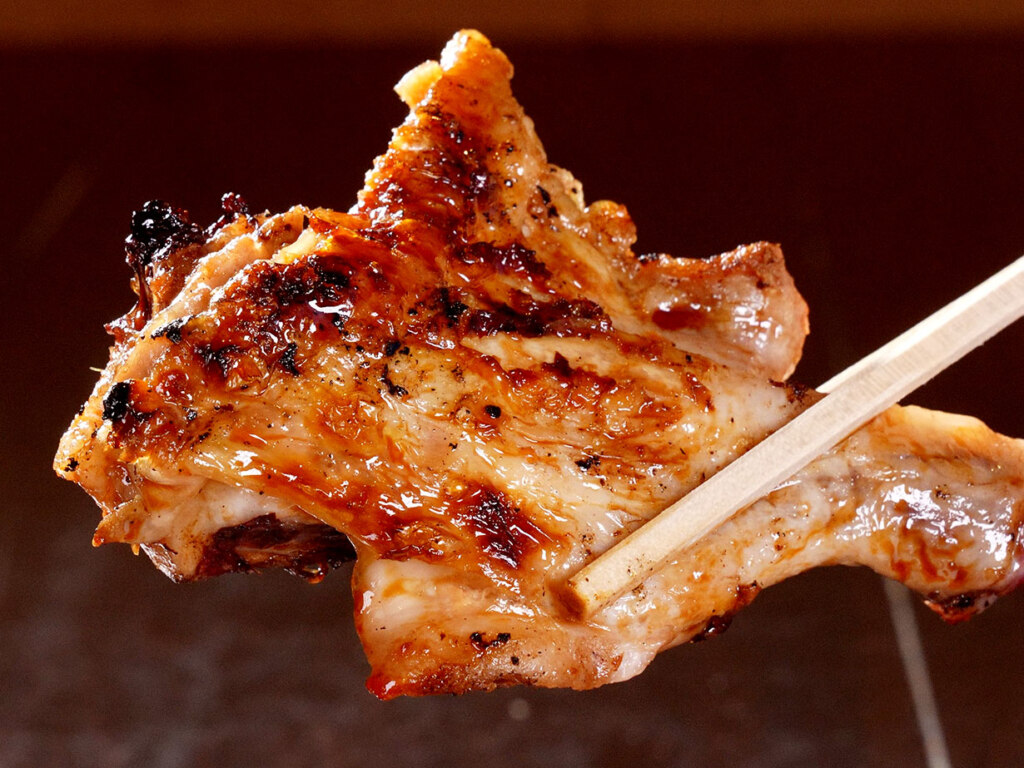 この新子焼きの照り！炭火でじっくりと焼き上げた半身は、皮目もパリッと。秘伝の甘辛ダレが味わいを深めています