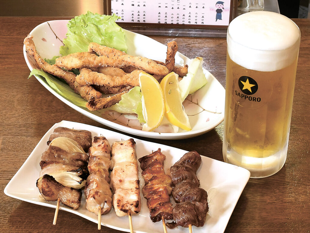 定番の鳥串(バラ、モモ、ムネ、皮/1本150円~)ととり胸肉のスティックからあげ(写真奥/500円)