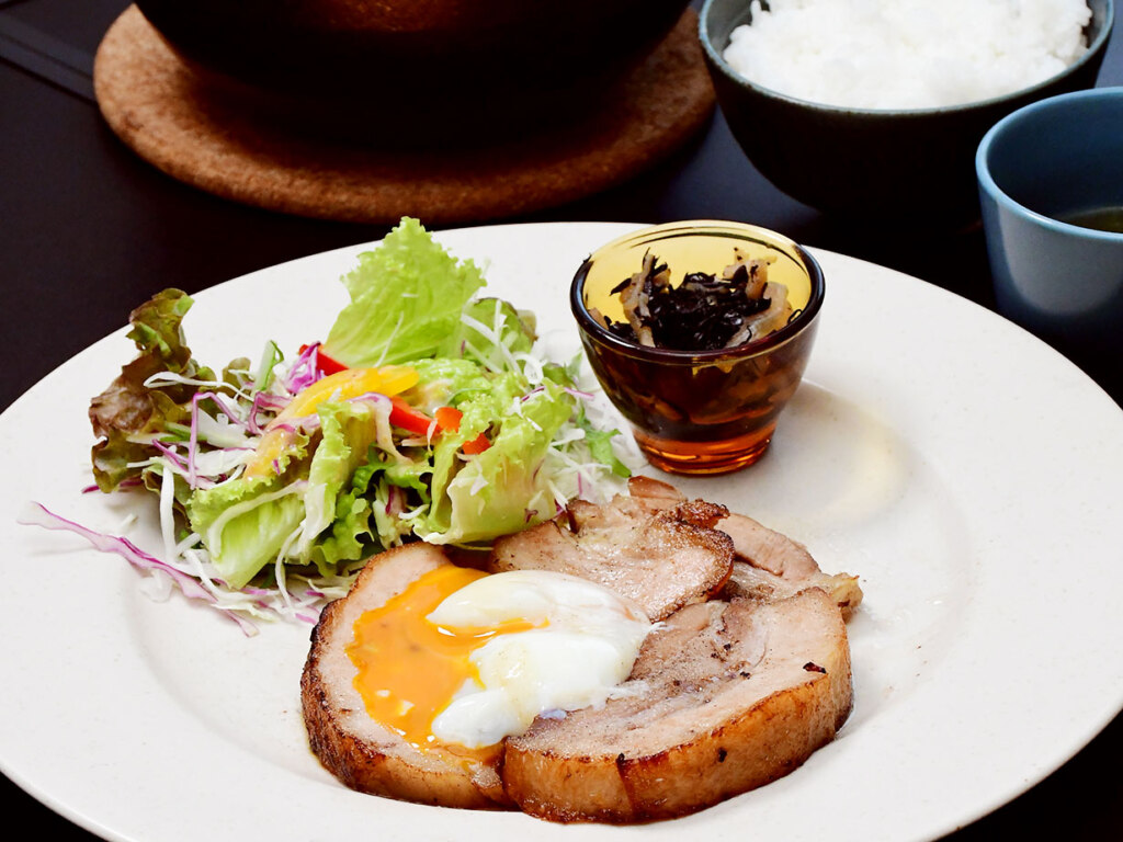 チャーシューエッグ1,100円。香ばしく焼き上げた分厚い煮込みチャーシューに温泉卵を絡めて。土鍋ご飯はおかわり自由!なので、お腹いっぱいどうぞ♪