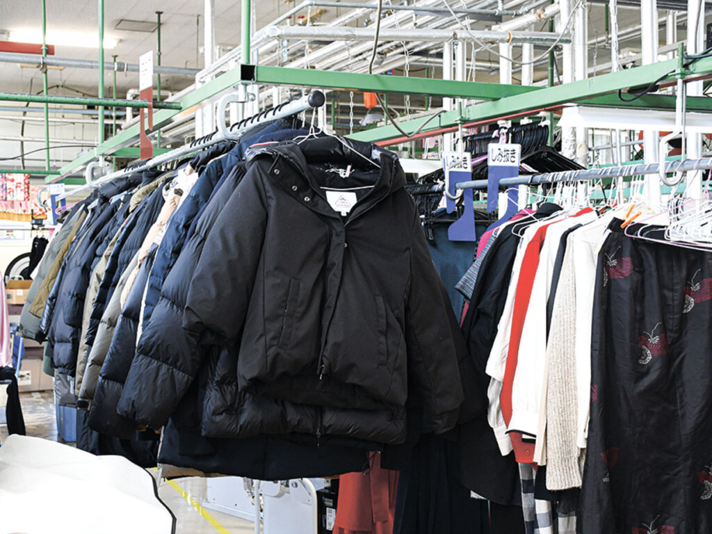 レーンに吊るされて洗濯を待つダウンの行列