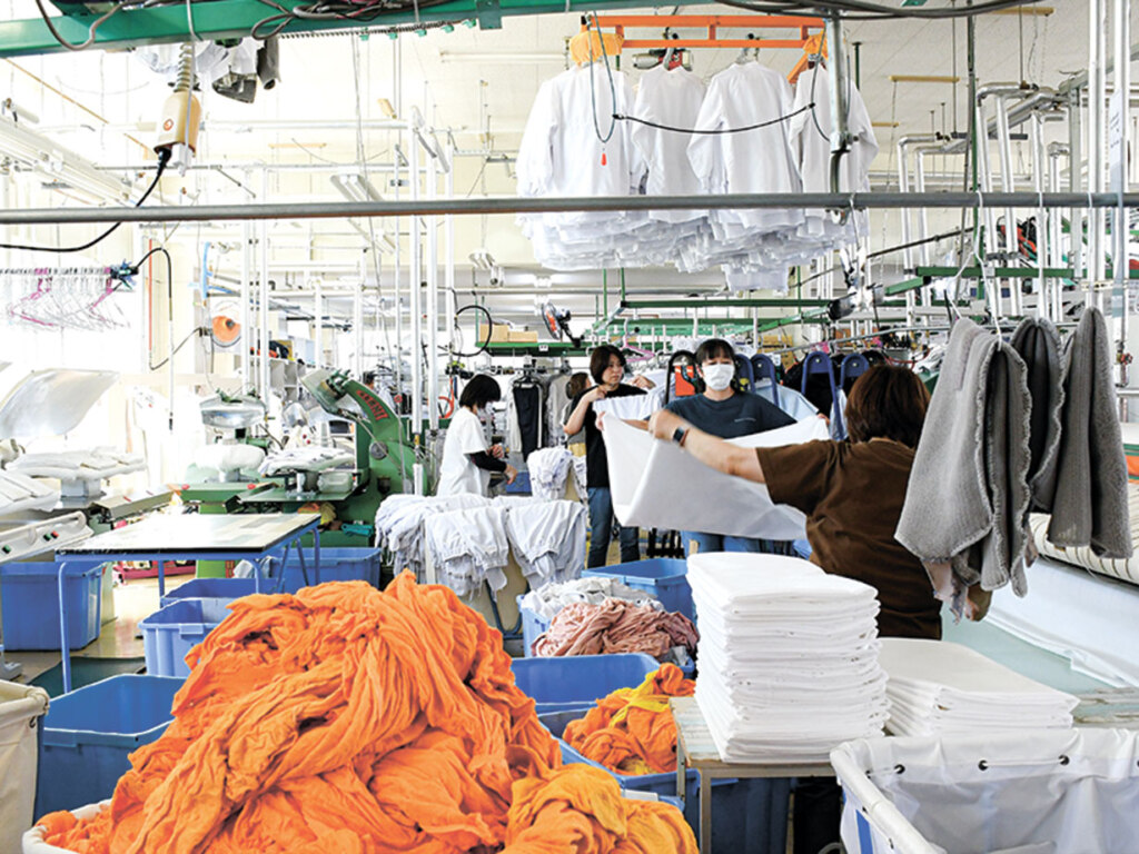 手前は大量のタオル。奥ではシーツを仕上げ中