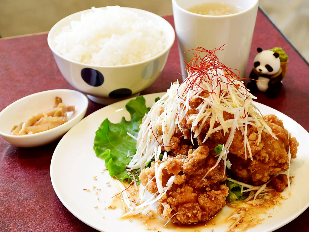 油淋鶏定食1,000円。カリッと揚げた大きな唐揚げに、たっぷりの香味ダレと白髪ネギをトッピング。セットの卵スープは自家製ラーメンスープがベースの力作です