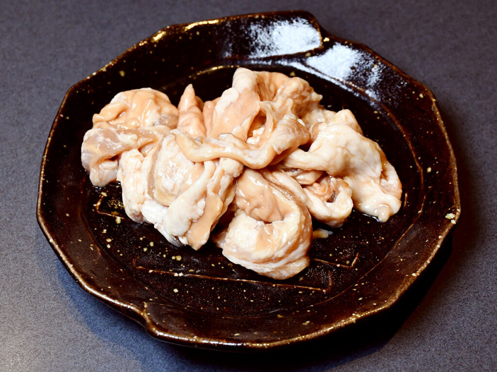 名物は、入店するとまず登場するお通しの醤油ホルモン。甘めの醤油ダレと、噛むほどに広がるホルモンの旨みが絶妙です。追加注文が入るほど人気の一品で、お土産用も店頭で販売中