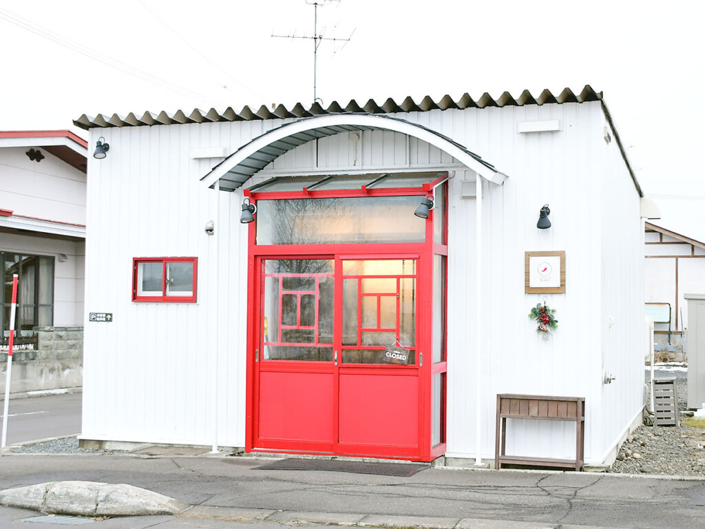 白壁に赤い入口の建物です
