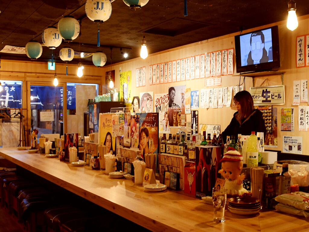 BGMは昭和歌謡、今はあまり見ることのないコの字カウンターで、昼から飲める酒場です。仕事帰りにくだを巻いたり、明るいうちに酔っぱらっても許してくれる、オープンな雰囲気が魅力(もちろんほどほどにね！)