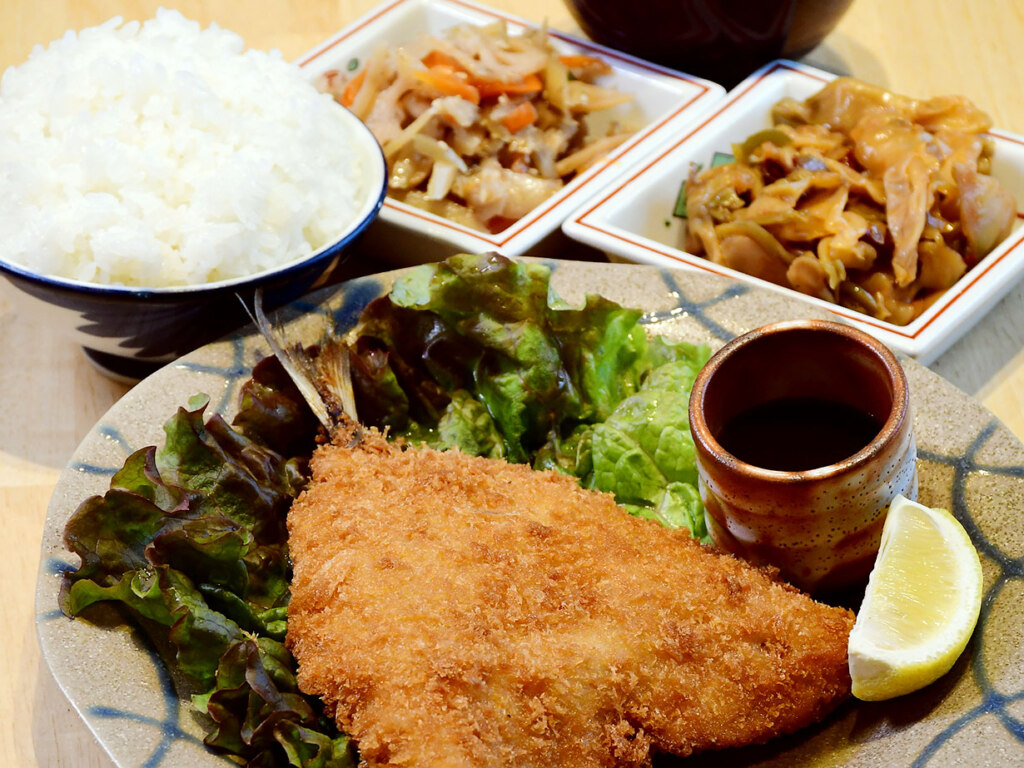 アジフライ定食1,200円。サクサク衣をまとった肉厚の身は、ふっくらジューシー！定食は全8種類あって、どれもボリューム満点。しっかりお腹を満たせると好評です