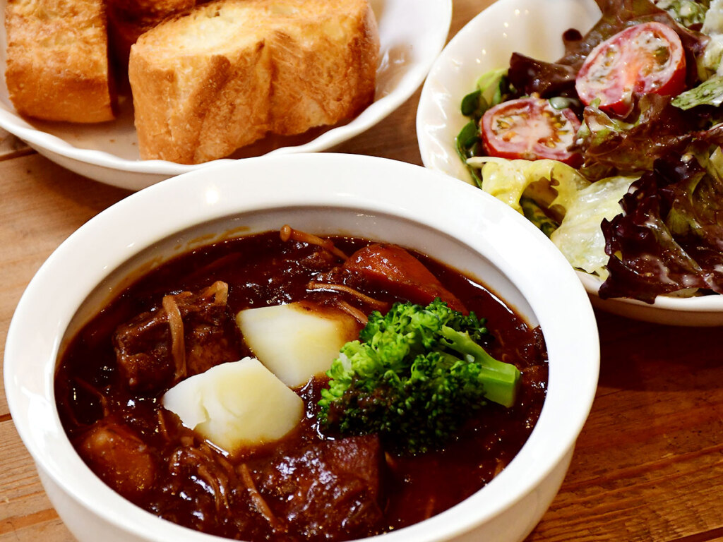 特製デミシチュー1,100円。2日かけて仕上げるソースには、ゴロゴロの豚肉やにんじん、ブロッコリー、えのきなど、たっぷり具材の旨みと野菜の甘みが溶け込んでいます。ご飯またはパン、サラダ付き