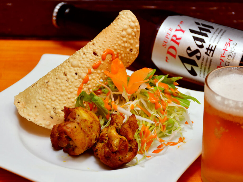 カレーをはじめ、おつまみメニューも豊富です。せんべろスタイルの「ビールセット」(1000円)はネパールの焼鳥「セクワ」と、豆から作るインドの薄焼きせんべい「パパド」、サラダ付き。ビールは数種類から選べます